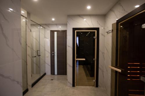 QaskelengArman Dala Resort的一间带步入式淋浴间和玻璃门的浴室