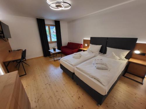 海德米赫莱Witikohof的一间卧室配有一张大床和一张红色的沙发