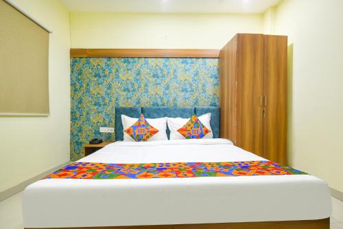 印多尔FabHotel Grand Giriraj的卧室配有一张大白色床和色彩缤纷的床单