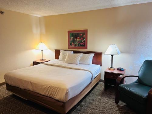 印第安纳波利斯Norwood Inn Statefare Grounds的配有一张床和一把椅子的酒店客房