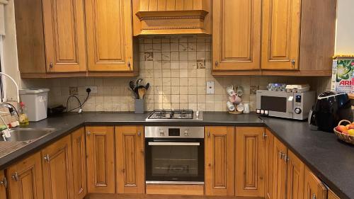 都柏林Mixed dormitory shared with other guests的厨房配有木制橱柜和炉灶烤箱。