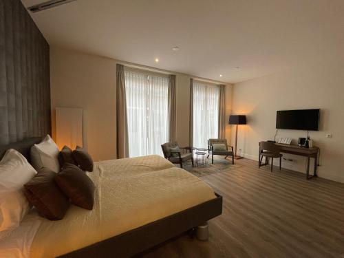 格罗宁根Woonlandschap De Leyhoeve Groningen的酒店客房配有一张床、一张书桌和一台电视。