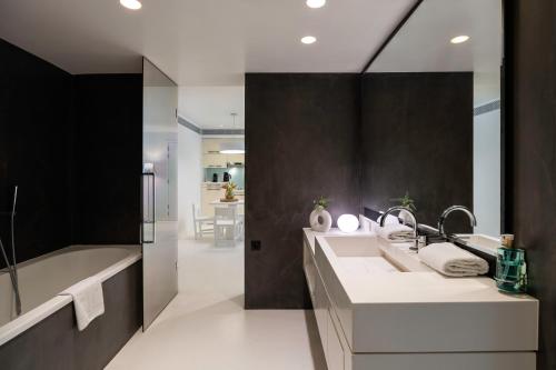 布鲁塞尔丽晶B公寓式酒店的浴室配有两个盥洗盆和浴缸。