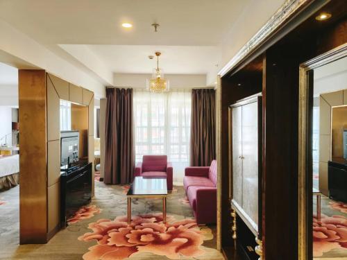 广州克莱顿酒店（近琶洲展馆）的客厅配有粉红色的沙发和电视