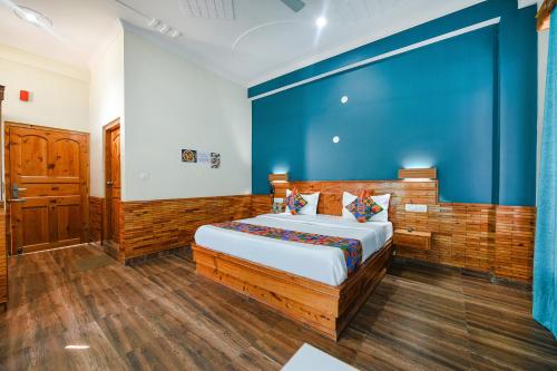 LārjiFabHotel Snower的一间卧室设有一张蓝色墙壁的大床