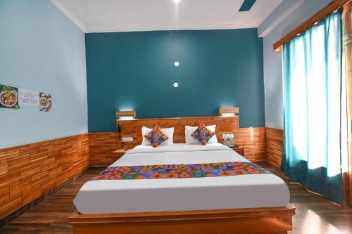 LārjiFabHotel Snower的一间卧室设有一张蓝色墙壁的大床
