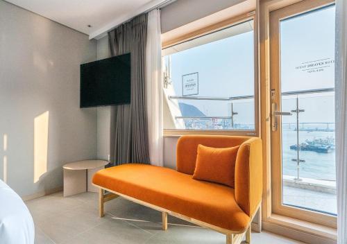 釜山Nampo Ocean2Heaven Hotel& Spa的窗户的橙色椅子