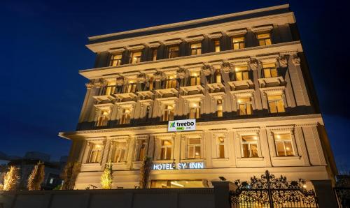 海得拉巴Treebo Trend SY Inn - Gachibowli DLF的一座有灯的建筑,上面有酒店标志