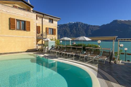 利莫内-苏尔加达Hotel all'Azzurro的酒店游泳池设有桌椅