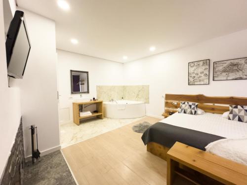 布拉索夫MiddleHouse的一间卧室配有一张床、一个浴缸和一台电视。