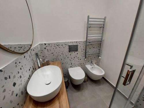 米兰Studio Donatello的浴室设有2个卫生间、水槽和镜子