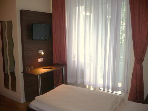 科隆阿里亚纳酒店的一间卧室设有一张床和一个带电视的窗户。