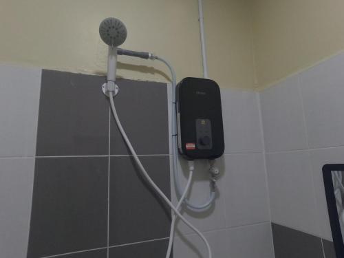 珍南海滩NURUL ROOMSTAY LANGKAWI的浴室设有淋浴,墙上配有电话