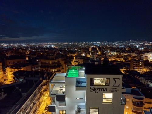 塞萨洛尼基SIGMA Luxury Apartments & Suites的夜空城市顶部的建筑物