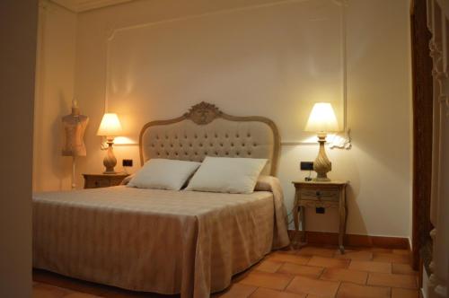 慕尼拉Hospedería Bodas de Camacho的一间卧室配有一张带两个枕头和两个灯的床。