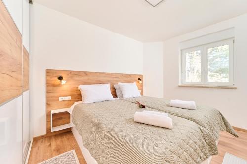 萨武德里亚Apartma Morje的白色卧室配有一张带两个白色枕头的大床