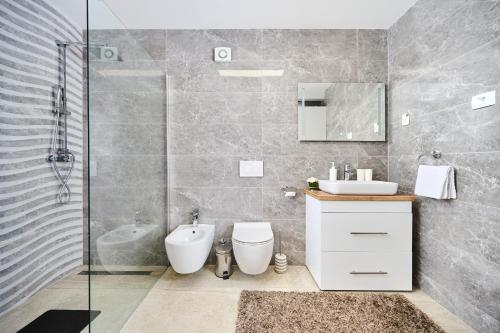 萨武德里亚Apartma Morje的浴室配有卫生间、盥洗盆和淋浴。