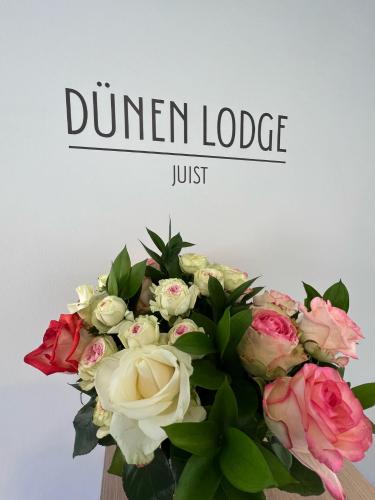 于斯德Dünen Lodge 5的花瓶里一束鲜花,上面写着晚餐小屋