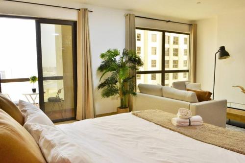 迪拜Vacation Home In Best Part of Dubai的卧室配有白色的床和沙发