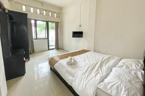 Kedemangan-wetanSalsabila Villa Syariah RedPartner的一间卧室配有一张床和一台平面电视
