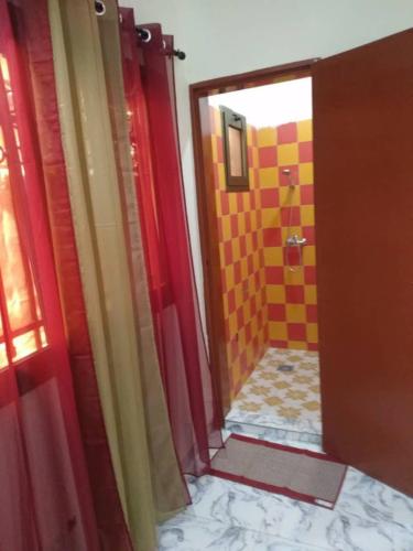 瓦加杜古Sawadogo meublée的浴室设有红色的门和黄色瓷砖淋浴。