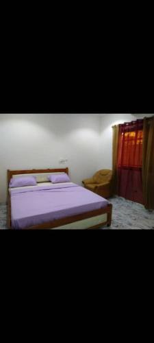 瓦加杜古Sawadogo meublée的一间卧室配有一张紫色床单的床
