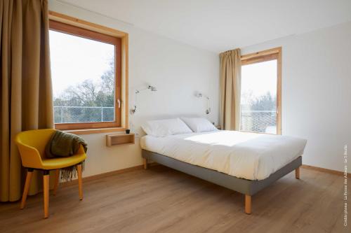 Arleux-du-NordLa Ferme Des Ailleurs的一间卧室配有一张床和一张黄色椅子