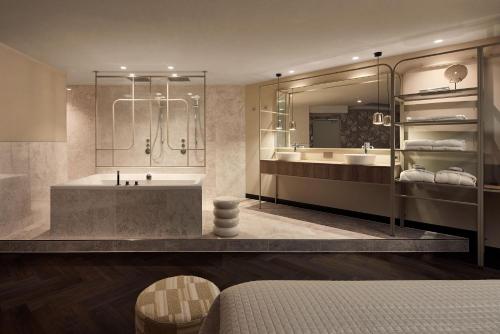 Zuidbroek格罗宁根基德罗伊克梵瓦尔克酒店的带浴缸、两个盥洗盆和淋浴的浴室。