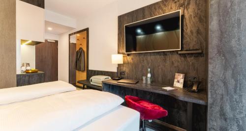 雷克林豪森PLAZA INN Recklinghausen的酒店客房设有两张床和电视。