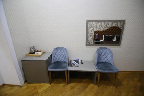 巴库Prime Hotel的一张桌子、两把椅子和一张带镜子的桌子