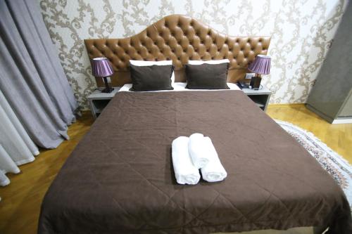 巴库Prime Hotel的一间卧室配有一张带两条白色毛巾的床
