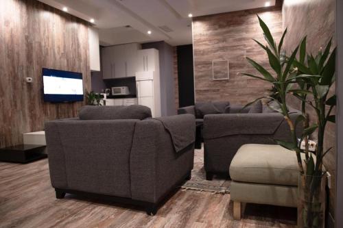 科威特Terrace Furnished Apartments Fintas 2的客厅配有两张沙发和一台电视