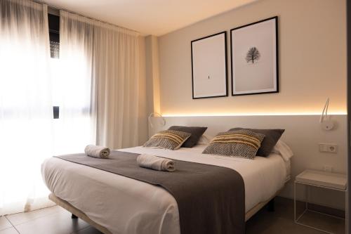 卡塔赫纳Apartamentos Turísticos Puerta Real的一间卧室配有一张大床和两个枕头