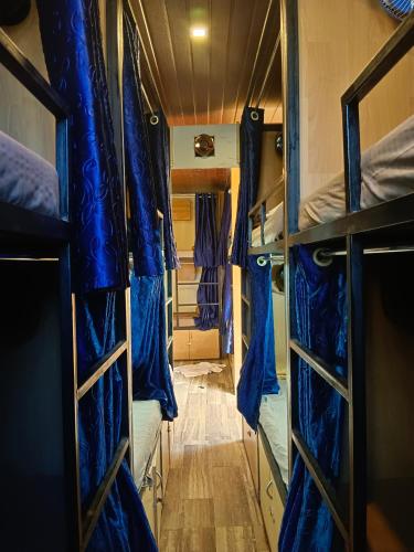 孟买Victory dormitory的小房间设有蓝色窗帘和地板