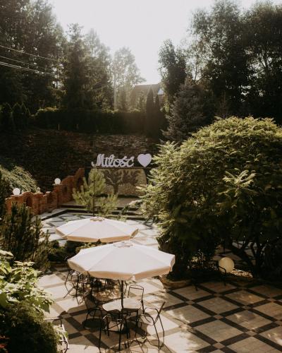 SuchedniówHotel Resident的花园内带桌椅的庭院