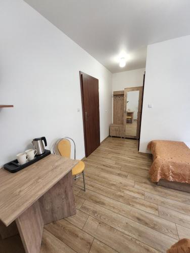 SuchedniówHotel Resident的客房设有木桌和床。