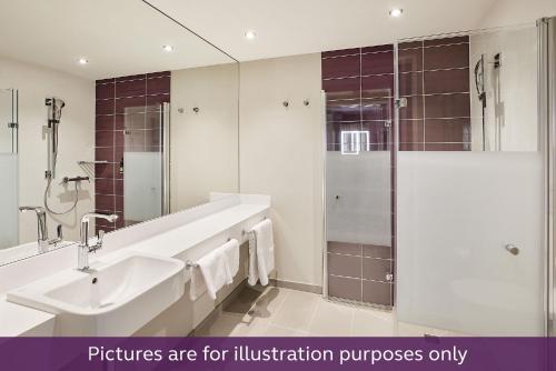 林道Premier Inn Lindau的白色的浴室设有水槽和淋浴。