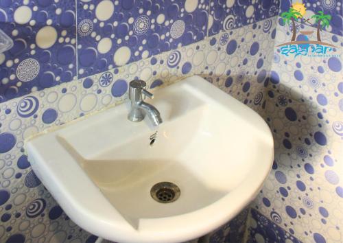 维沙卡帕特南Saghar House的墙壁上的浴室里设有一个白色水槽