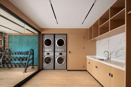 江门江门新会希尔顿花园酒店(双水大道中店) 的洗衣房配有2台洗衣机和烘干机