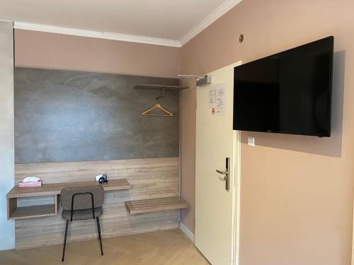 杜塞尔多夫Hotel Petite Königsallee SELF CHECK-IN的一间房间,配有一张桌子和一台墙上的电视