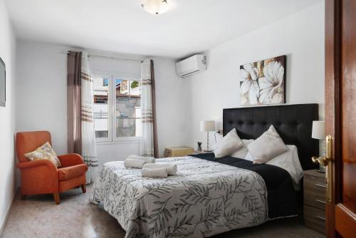 卡门港Villa Muñoz的一间卧室配有一张大床和一把椅子