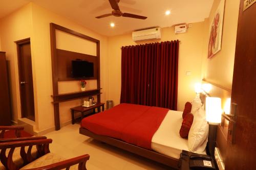 杜蒂戈林Hotel Nakshatra Inn VL Tuticorin的酒店客房,配有一张带红色毯子的床