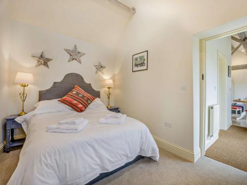 Kemble1 Bed in Cirencester 57684的卧室配有白色的床铺,墙上挂着星星