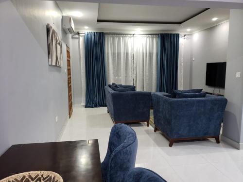 奇帕塔The KWASU Apartments的客厅配有蓝色的椅子和桌子