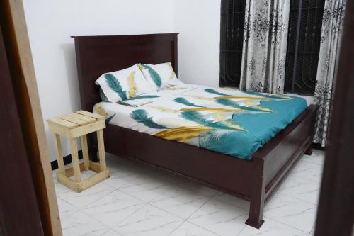 达累斯萨拉姆2 Bedroom spacious Cozy Home in Kigamboni,10 min Walk to Beach的一间卧室配有一张带木制床头板的床和一张睡床。