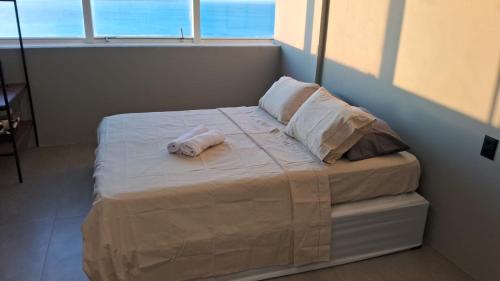 萨尔瓦多Sol Victoria Marina Flat的房间里的一张带毛巾的床