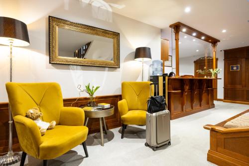 尤尔马拉Villa Alvīne Family Apart-Hotel的一间设有两张黄色椅子和泰迪熊的等候室