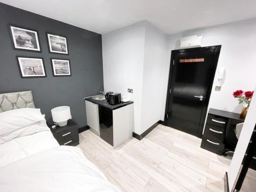 PinnerLetzi Private En-Suite In Harrow的一间卧室设有一张床和一个黑色的门