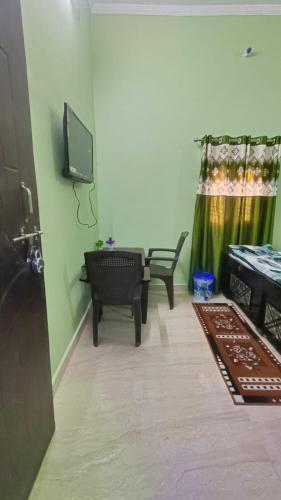AyodhyaPrakash Homestay的客厅配有电视、沙发和椅子