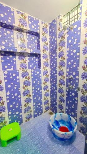 AyodhyaPrakash Homestay的浴室拥有蓝色和白色的墙壁,并装饰有紫色的鲜花
